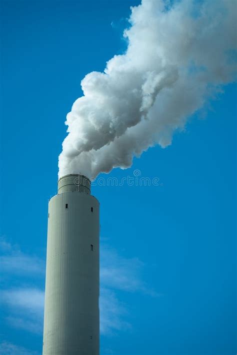 Single Smoke Stack Blowing White Puffy Smoke Into Blue Sky Landscape