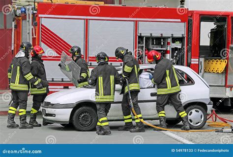 Brave Firefighters Relieve An Injured After A Road Accident Stock Image