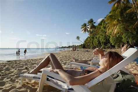 Kvinde solbadning på stranden Stock foto Colourbox