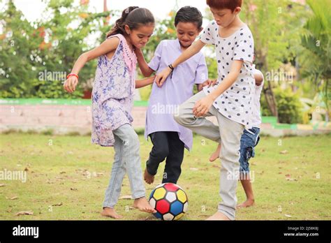 group of multiethnic diverse kids playing football at park - concept of ...