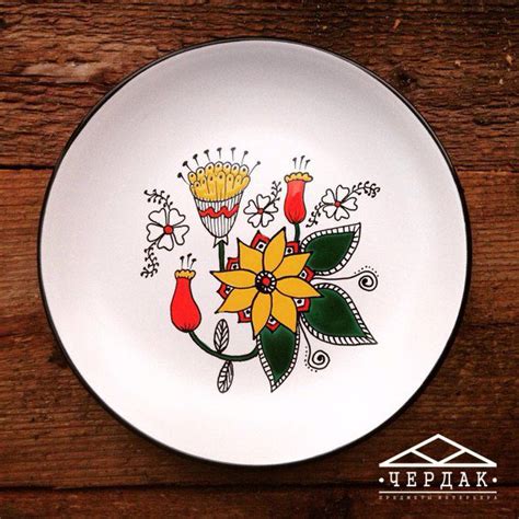 A White Plate With Flowers Painted On It Sitting On Top Of A Wooden