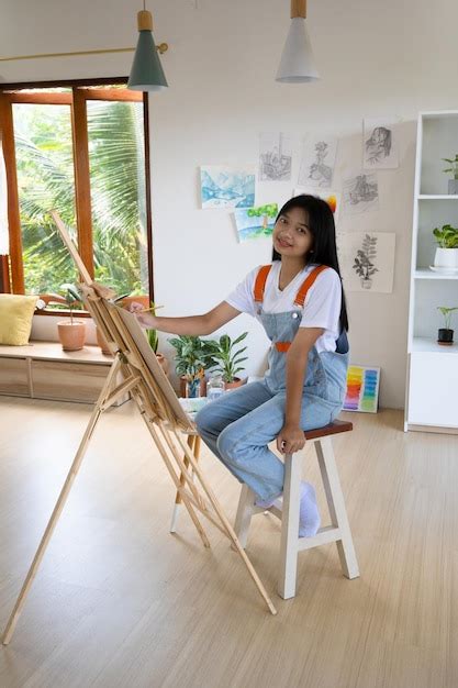 Niña pintando sobre papel en casa marco de maderahobby y estudio de