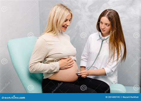 Female Doctor Using Stethoscope Examining Pregnant Woman In Clinic