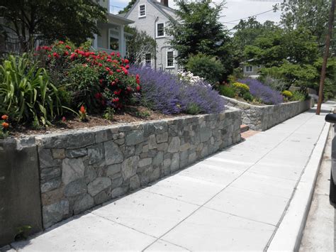 Stone retaining walls in the front yard are eye-catching and provide ...