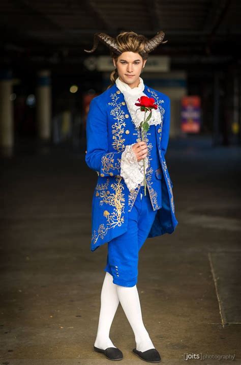 a man dressed in blue and white with horns on his head, holding a red rose