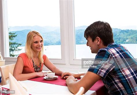 Smiling Couple Holding Hands And Drinking Coffee In Cafe Photos And