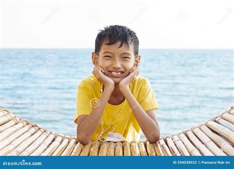 Asian Boy Standing Smile And Looking Camera By The Sea While Traveling