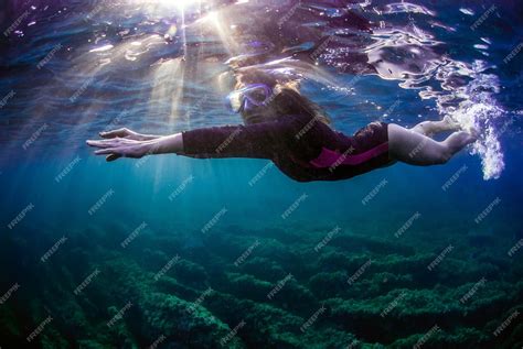 Mujer Joven Nadando En El Océano Al Atardecer Foto Premium