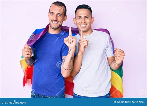 Joven Pareja Gay De Dos Hombres Sosteniendo La Bandera Lgbtq Arcoiris Juntos Sonriendo Con Una