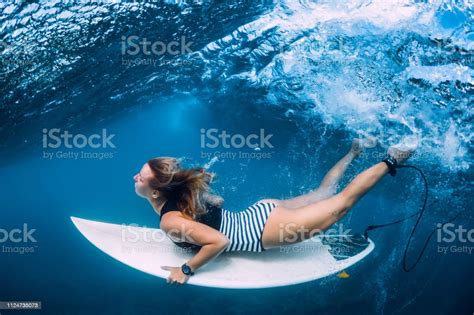 Surfer Girl With Surfboard Dive Underwater With Fun Under Ocean Wave