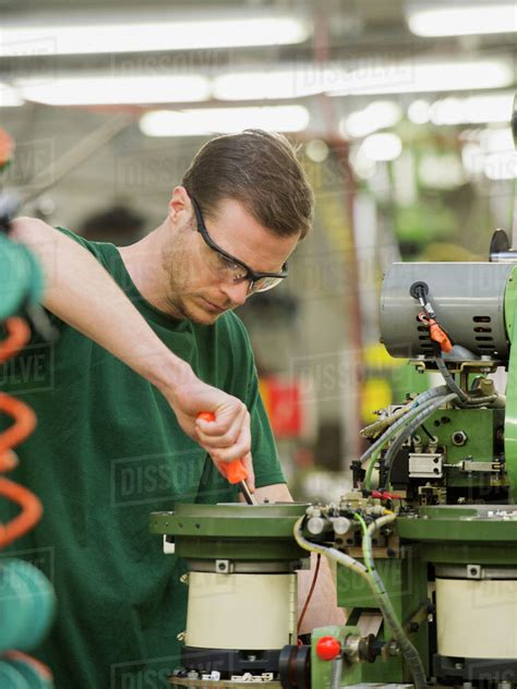 Caucasian Worker Operating Machinery In Textile Factory Stock Photo