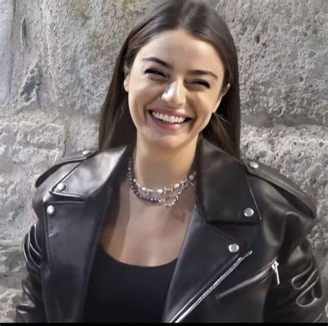 A Woman Wearing A Black Leather Jacket And Smiling At The Camera While