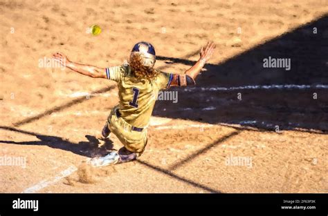 A Female Softball Player Is Sliding Into Home Base Stock Photo Alamy