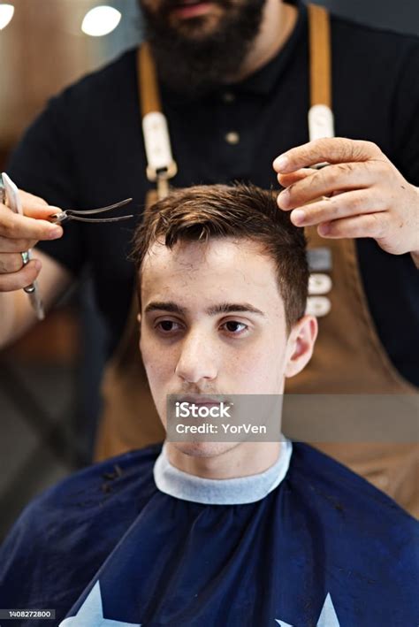 Professional Barber Giving A Customer A Haircut In His Barber Shop