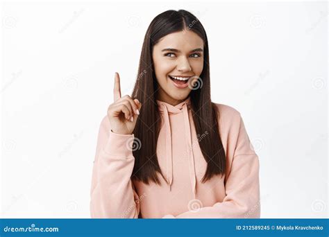 Cunning Brunette Girl Smiling And Chuckling Looking Aside Thoughtful And Raising Finger Up
