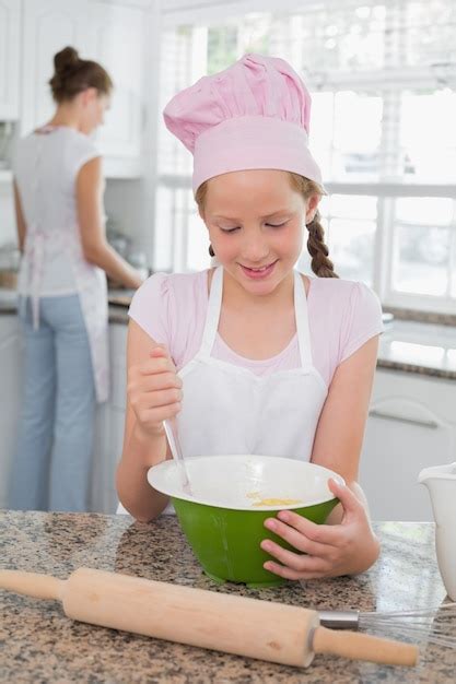 Chica Ayudando A Su Madre A Preparar Comida En La Cocina Foto Premium