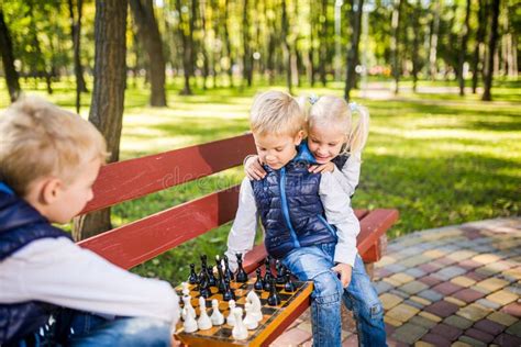 Petits Coliers Jouer Aux Checs Dans Le Parc Sur Le Banc Jeux