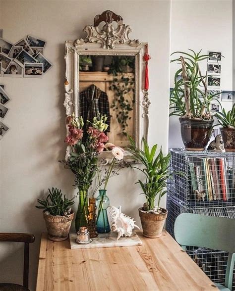 A Wooden Table Topped With Potted Plants Next To A Mirror And Bookshelf