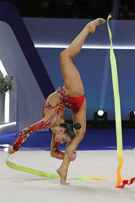 A Woman Doing A Handstand On Top Of A Pole