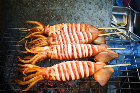 Grilled squid on the grill grate / delicious seafood squid grilled in ...