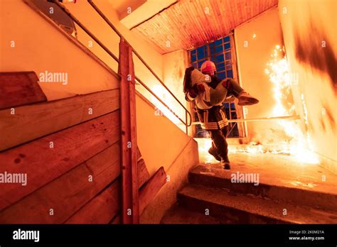 Brave Fireman Descends Stairs Of A Burning Building And Holds Saved