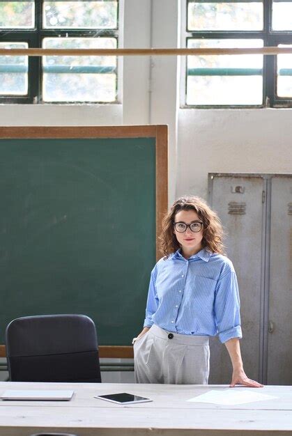 Premium Photo Young Woman School Teacher Standing At Desk In Front Of