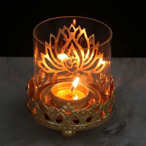 A Lit Candle In A Glass Holder On A Marble Countertop With A Black Background