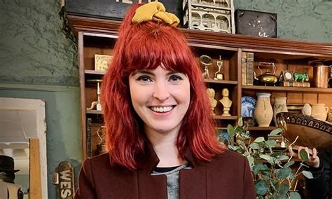 a woman with red hair standing in front of a shelf