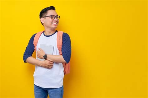 Sonriente joven estudiante asiático con ropa informal y mochila con