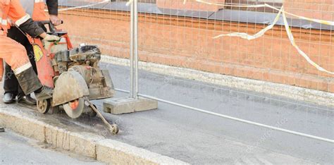 Trabajador De La Carretera Que Corta La Carretera De Asfalto