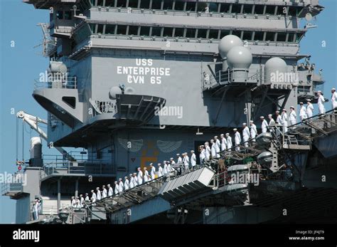 Crewmembers Of The Uss Enterprise Cvn Man The Rail As The Aircraft