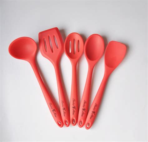 Five Red Utensils Are Lined Up On A White Surface With Chinese Writing