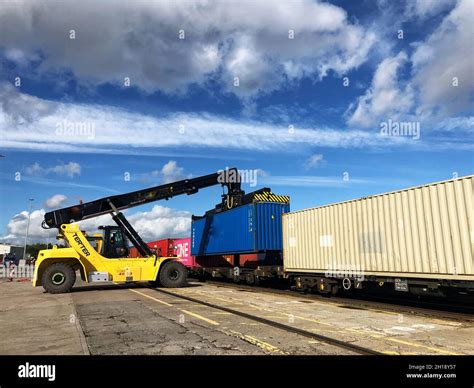 A Heavy Lifting Crane Machine Loading A Shipping Container Onto A