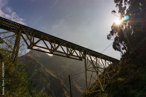 Puente férreo vista desde abajo con los rayos del sol en el atardecer