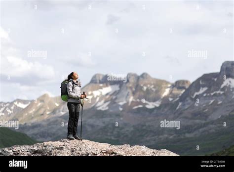 Full Body Portrait Of A Hiker Breathing Fresh Air In A High Mountain