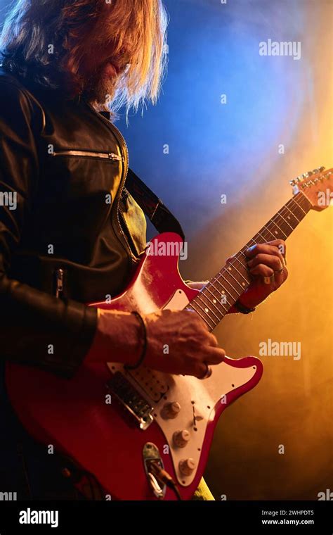 Ambient Vertical Portrait Of Long Haired Rock Musician Playing Electric