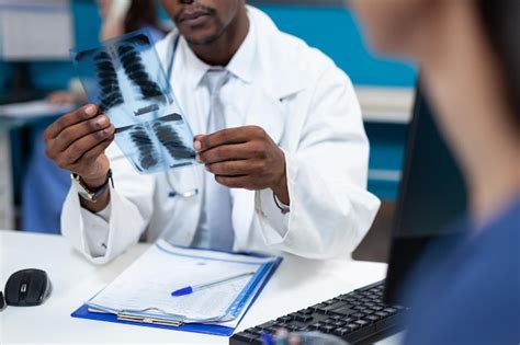 Primer plano de un médico pediatra afroamericano con radiografía de los