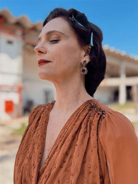 A Woman With Her Eyes Closed Standing In Front Of A House