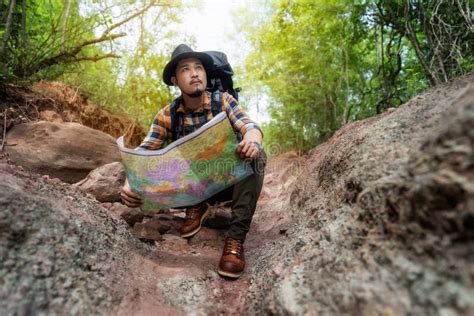 Homem Viajante Mochila Sentada E Lendo Mapa Na Floresta Imagem De