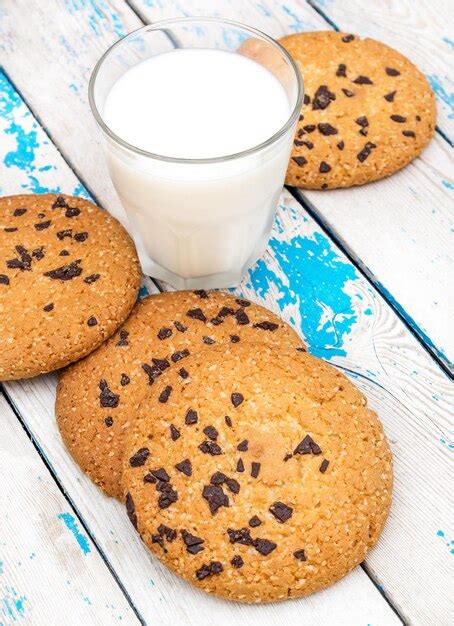 Vaso De Leche Y Galletas Con Trocitos De Chocolate En La Vieja Mesa De