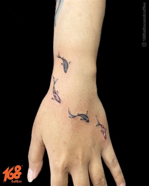 A Person S Hand With Fish Tattoos On The Left Side Of Their Arm And Wrist