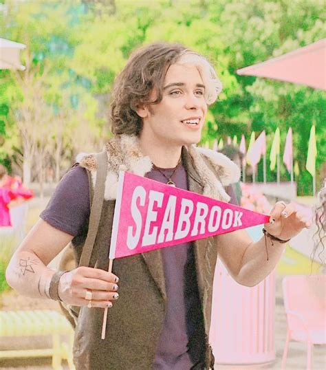 A Man Holding A Sign With The Word Seabrook On It In Front Of Him