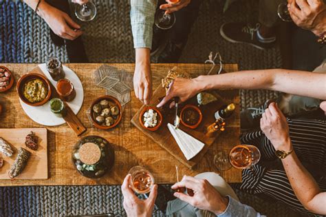 Top View Of People Gathering Around Table Details On Appetizers And