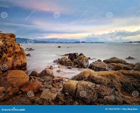 Sunset on rock beach stock photo. Image of silky, stones - 155218794