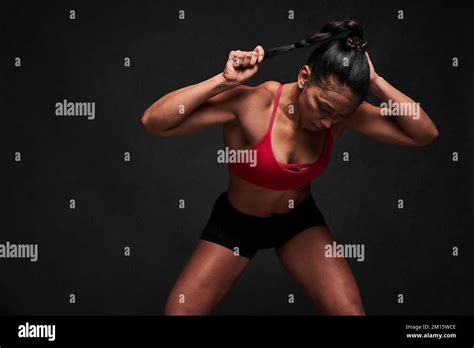 Fit Hispanic Female Athlete In Tight Activewear Pulling Pigtail While