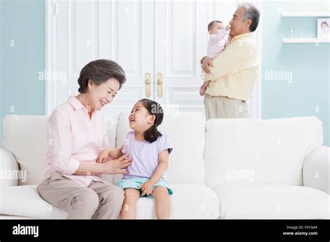 Grandmother Having Fun With Her Granddaughter And Grandfather Holding A