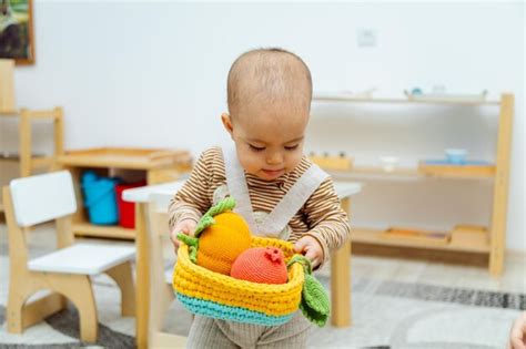 Ni O Jugando Con Canasta De Frutas Tejidas Foto Premium