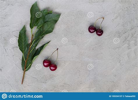 Cerezas Rojas Frescas Con Las Hojas Verdes En Una Tabla Gris Imagen De