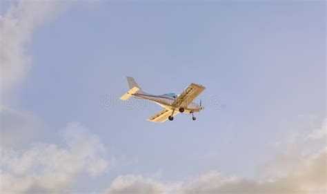 A Light Plane Flying Through The Clouds At Sunset Stock Photo Image