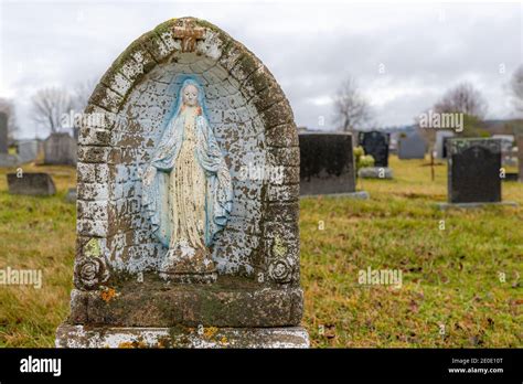 Une petite statue de la Vierge Marie dans une alcôve dans un cimetière